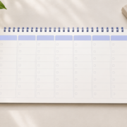 Weekly revision planner beside textbooks, a pencil and indigo progress tabs.